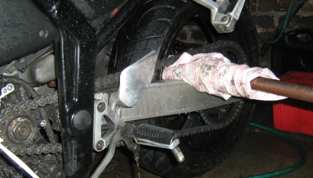 the metal bar through the back wheel against the swingarm to loosen the sprocket nut